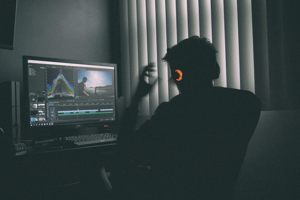 Editor wearing headphones working on a video timeline